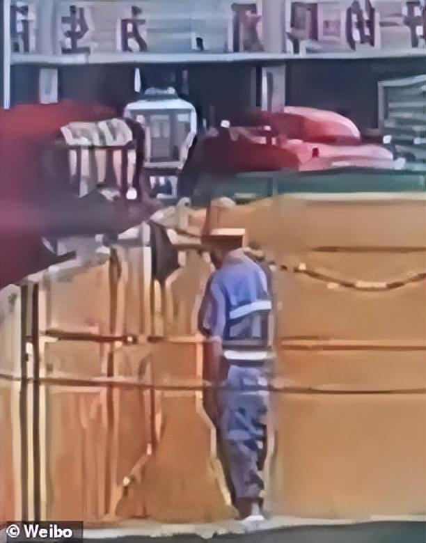 该男子在帮助从卡车上卸下麦芽时，向一个刚刚倒空的麦芽容器里小便